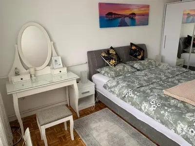a bedroom with a bed and a dressing table and a mirror at Apartman Nova Varos in Banja Luka