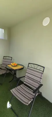 two chairs and a table in an empty room at Apartman Ela in Banja Luka