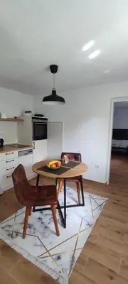 a kitchen with a table and a chair in a room at Apartman Ela in Banja Luka
