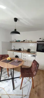 a kitchen with a table and chairs in a room at Apartman Ela in Banja Luka