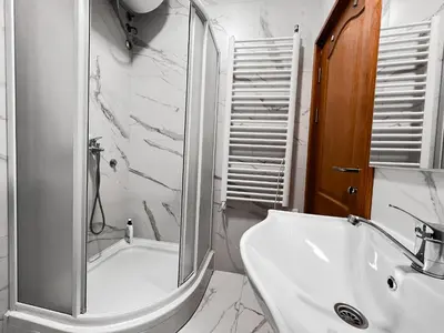 a white bathroom with a shower and a sink at Stan na dan Sebastijan in Banja Luka