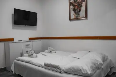 a bedroom with a bed with a tv on the wall at Stan na dan Sebastijan in Banja Luka