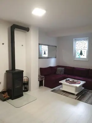 a living room with a couch and a wood stove at Apartman 