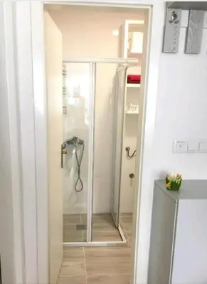 a shower with a glass door in a bathroom at Apartman 