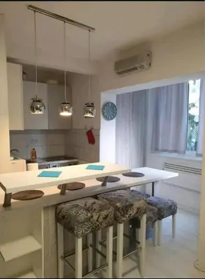 a kitchen with a table and two bar stools at Apartman 