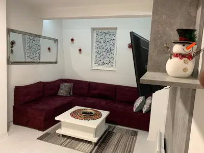 a living room with a red couch and a snowman at Apartman 