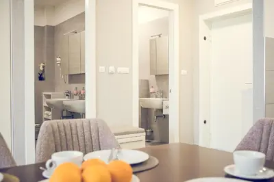a dining room with a table and two sinks at Apartmani SL Luxury in Banja Luka