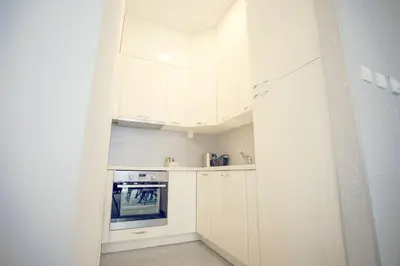a small kitchen with white cabinets and an oven at Apartmani SL Luxury in Banja Luka