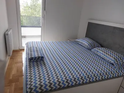 a bedroom with a bed with a blue comforter and a window at Zidart lux in Pištelići