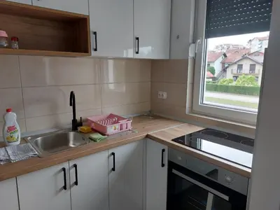 a kitchen with white cabinets and a sink and a window at Zidart lux in Pištelići