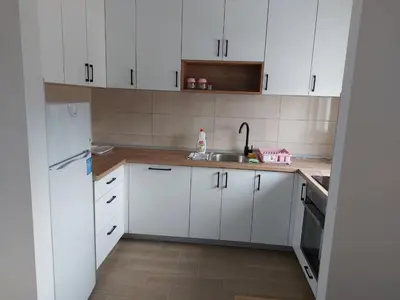 a kitchen with white cabinets and a sink at Zidart lux in Pištelići