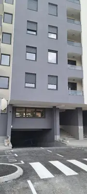 a tall building with a parking lot in front of it at Zidart lux in Pištelići