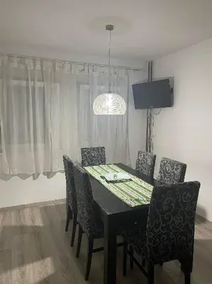 a dining room table with chairs and a chandelier at Bajka centar in Bosanska Gradiška