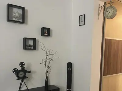 a room with a white wall with pictures and a clock at Bajka centar in Bosanska Gradiška