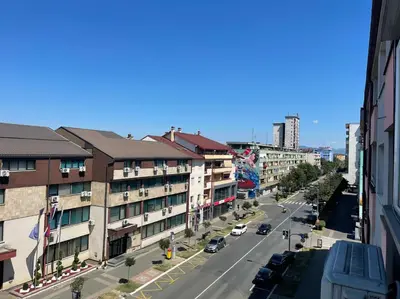 a city street with buildings and cars on the road at Bajka centar in Bosanska Gradiška
