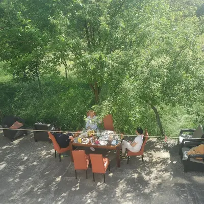 a group of people sitting around a table with food at Vila Zvizdic- apartman in Ilijaš