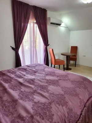 a bedroom with a pink bed and a window at Vila Zvizdic- apartman in Ilijaš
