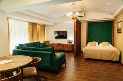 a hotel room with a bed and a couch and a table at Edemus - Motel & Restaurant in Maglaj