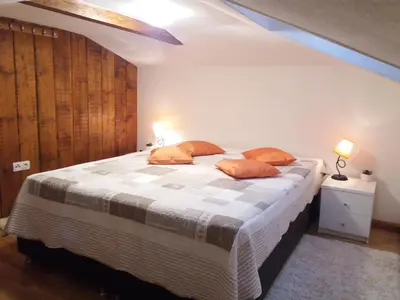 a bedroom with a large bed with orange pillows at Apartman Nancy Vlašić in Vlasic
