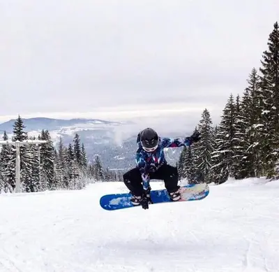 a person on a snowboard doing a trick in the snow at Apartman Nancy Vlašić in Vlasic