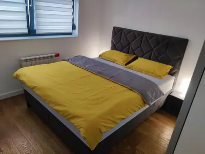 a bed in a bedroom with a yellow bedspread at Yellow Submarine apartment Banja Luka in Banja Luka