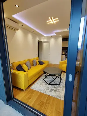 a living room with a yellow couch and a table at Yellow Submarine apartment Banja Luka in Banja Luka