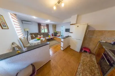 a kitchen and living room with a couch and a refrigerator at Apartman Ozimice 2 in Bihać
