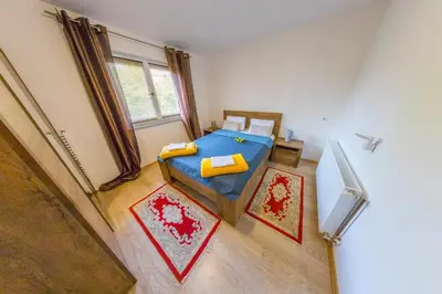 a bedroom with a bed and a refrigerator in it at Apartman Ozimice 2 in Bihać