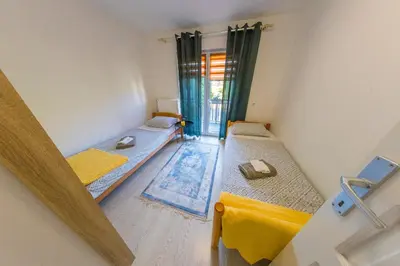 a room with two beds and a window at Apartman Ozimice 2 in Bihać