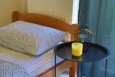 a black table with a glass of orange juice on a bed at Apartman Ozimice 2 in Bihać