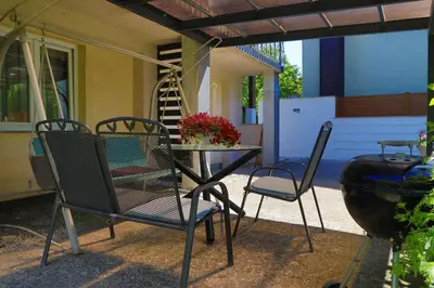 a patio with chairs and a table and a table and chairs at Apartman Ozimice 2 in Bihać