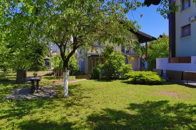 a yard with a tree and a building at Apartman Ozimice 2 in Bihać
