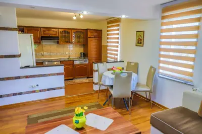 a kitchen with a table and chairs in a room at Apartman Ozimice 2 in Bihać
