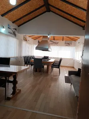 a dining room with tables and chairs and windows at Apartman Kaja in Kupres