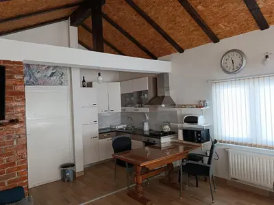 a kitchen with a table and a clock on the wall at Apartman Kaja in Kupres