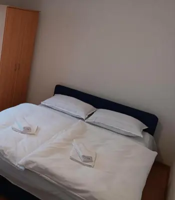 a bed with two white pillows and a blue headboard at Apartman Kaja in Kupres