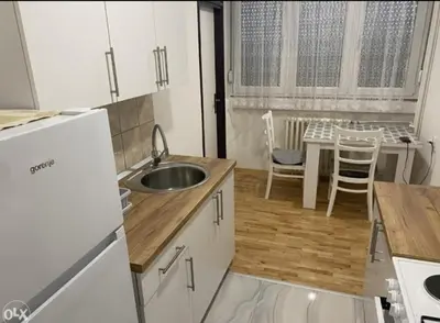 a kitchen with a sink and a table with chairs at Stan na dan Tenis in Prijedor