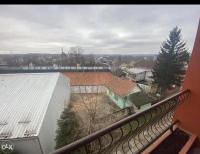 a balcony with a view of a building and a train at Stan na dan Tenis in Prijedor