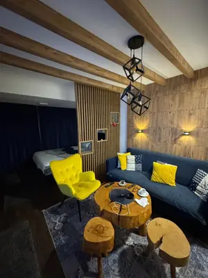 a living room with a blue couch and a yellow chair at Apartment Blue Eko Fis Vlašić in Vlasic