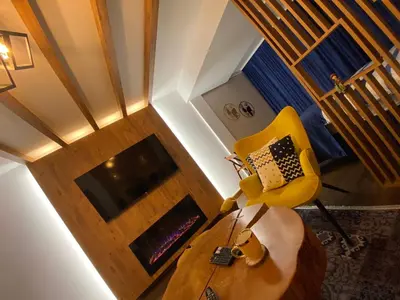 a living room with a yellow chair and a table at Apartment Blue Eko Fis Vlašić in Vlasic
