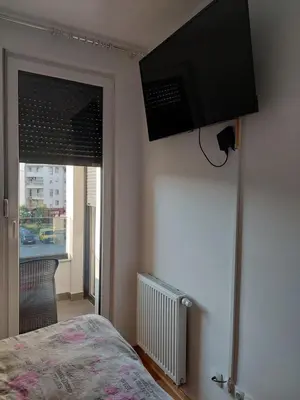 a bedroom with a bed and a flat screen tv on the wall at Sunrise Apartments in Banja Luka