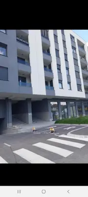 a large white building with a crosswalk in front of it at Sunrise Apartments in Banja Luka