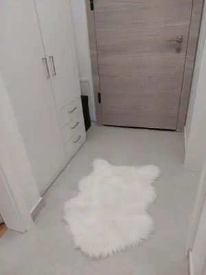 a white rug on the floor in a room with a door at Sunrise Apartments in Banja Luka