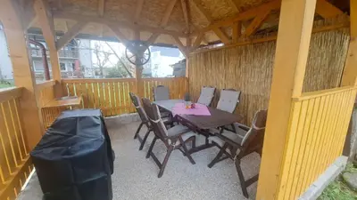 a wooden table and chairs on a patio at Begova kuća-Velika Kladuša in Velika Kladuša