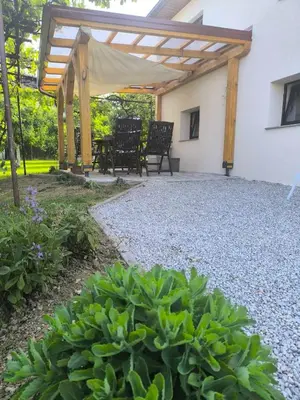 a patio with a table and chairs under a wooden pergola at Begova kuća-Velika Kladuša in Velika Kladuša
