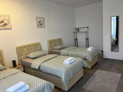 a room with three beds and a mirror at Apartmani Marić in Gornji Vakuf
