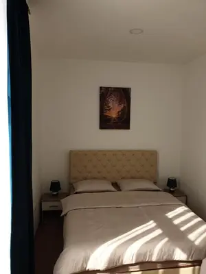 a bed in a bedroom with a picture on the wall at Apartmani Marić in Gornji Vakuf