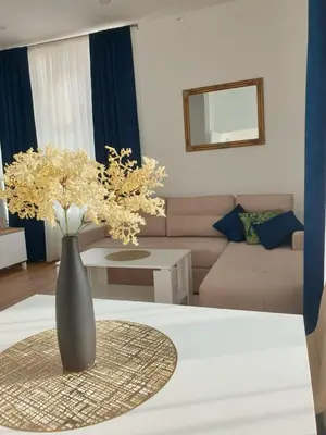 a vase with flowers on a table in a living room at Apartmani Marić in Gornji Vakuf