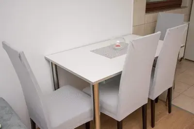 a white dining room table with white chairs at Apartman Vesna in Doboj