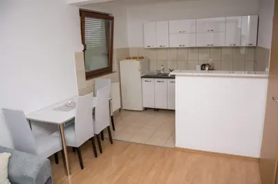 a kitchen with a table and chairs and a refrigerator at Apartman Vesna in Doboj